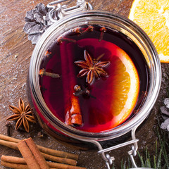 Christmas drink with orange fruit, anise, cinnamon and cloves on wooden table
