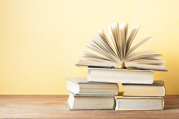 Open book, hardback books on wooden table. Education background. Back to school. Copy space for text.