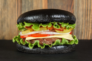 Black burger on wood background