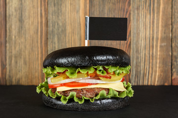 Black burger with flag on wood background