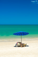 Beach chairs on the sand beach with cloudy blue sky