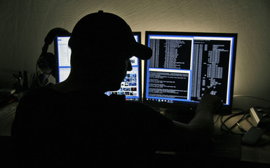 Computer Hacker blickt auf zwei Monitore