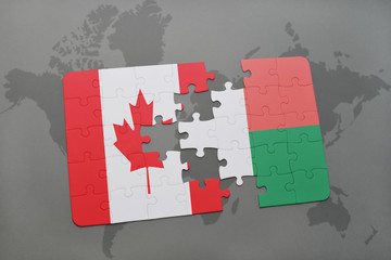 puzzle with the national flag of canada and madagascar on a world map background.