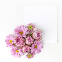 Obraz na płótnie Canvas Pink flowers bouquet with empty card. Top view. Flat lay