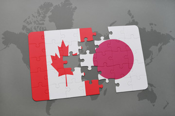 puzzle with the national flag of canada and japan on a world map background.
