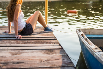 Woman in sneakers on a pier at the water