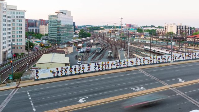Trains depart a busy station in Washington DC in time-lapse with crossing traffic
