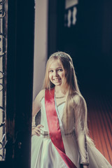 small girl with miss ribbon in dress