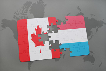 puzzle with the national flag of canada and luxembourg on a world map background.