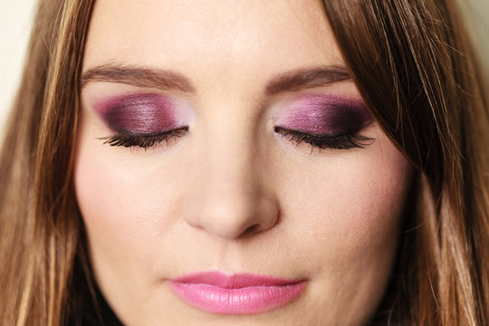 Woman closed eyes with violet dark shadows makeup