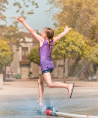 Girl is enjoying fountain with cold water