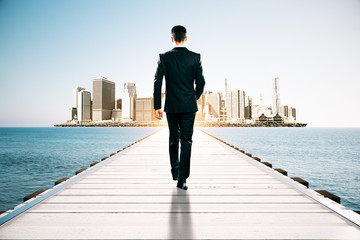 Businessman walking towards city