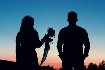 Silhouetted loving couple at sunset