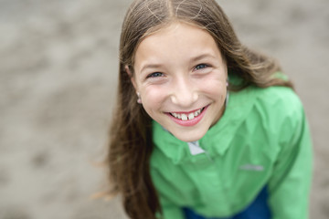 Girl enjoying the rain and having fun outside on the beach  a gray rainy