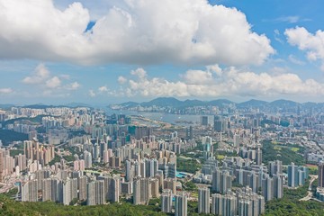 View of Hong Kong during the day - Hong Kong buildings and Victoria Harbor with blue sky clouds

