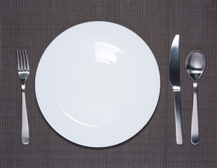 Blank white dish, fork, spoon and knife
