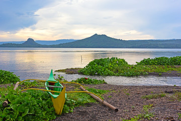 Phishing boat on a shore of beautiful Lake Taal, Philippines. Landscape of Luzon Island with volcano on the lake that changed the area geometry a few centuries ago.