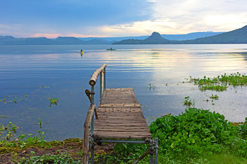 Fishermen boats on the lake Taal at sunrise, Philippines. Lake Taal panorama with mountains on horizon.