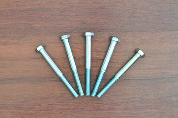 Metal screw on wooden background