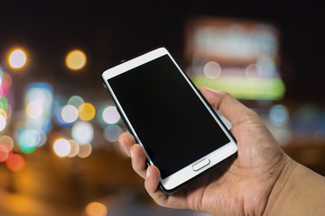 Hand hole smart phone on abstract blurred bookeh background