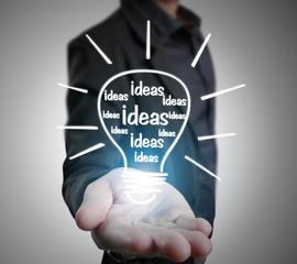 Hands of business person holding light bulb