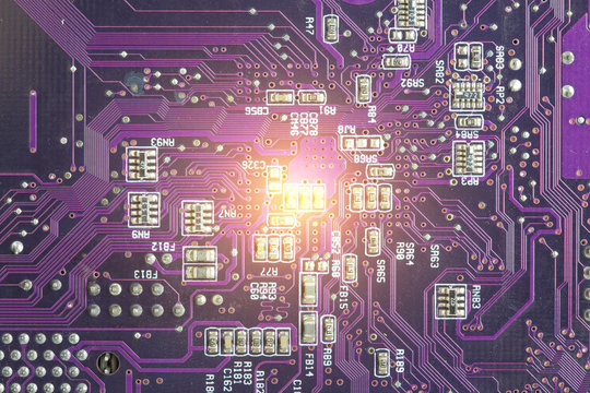 Close up of purple electronic circuit board and light center background.