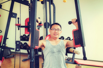 Fototapeta na wymiar Asia man middle aged training arm equipment in the gym for strength, weight loss.