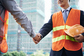 Cropped image of investor and contractor shaking hands