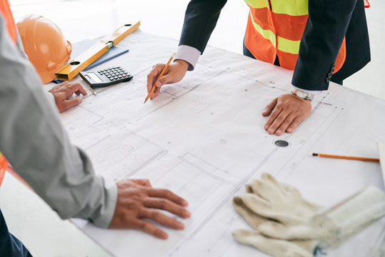 Engineer and contractor discussing draft on the table
