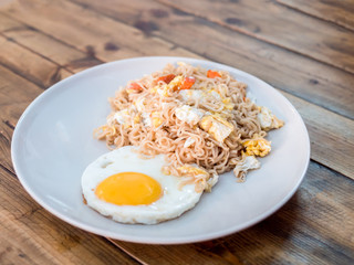 delicious noodle with sunny up fried egg on the wood table