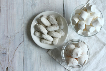 Fototapeta na wymiar Marshmallows, cookies in a dish on a wooden background. Monochrome
