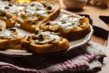Crostini with fried mushrooms, onion and mozzarella cheese