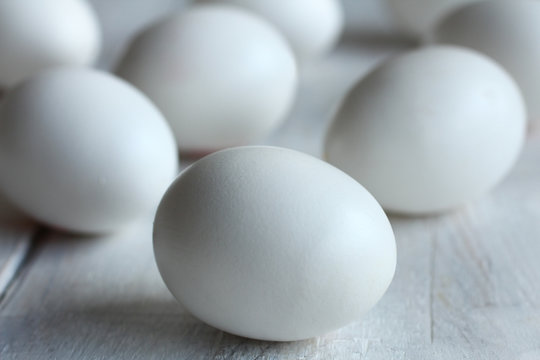 white chicken eggs on wooden background.Monochrome