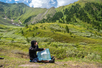 Tourist sitting with a map in hand and looking through binoculars