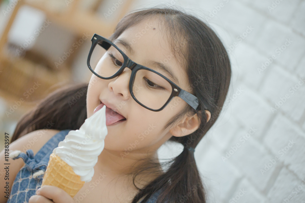 Wall mural Happy Asian girl enjoy eating soft ice-cream