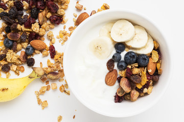 Fototapeta premium brunch : homemade yogurt with granola and banana in bowl on white table background. 