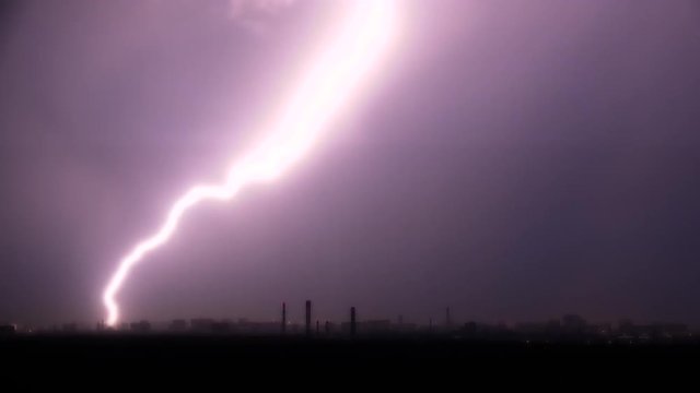 Lightning flashes over a city during a strong thunderstorm.