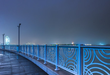 a walking bridge over rier with city skyline background,tianjin china.