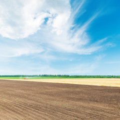 aerial view to black and golden agricultural fields under blue s