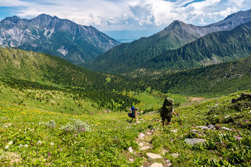 Fototapeta na wymiar Tourists descend from the pass Arshansky in Tunka range