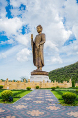 Giant golden buddha standing scenic in buddhist place at thipsukontharam temple, huai krachao, kanchanaburi, thailand