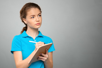 Obraz premium Pretty young beautiful woman standing, writing, take notes