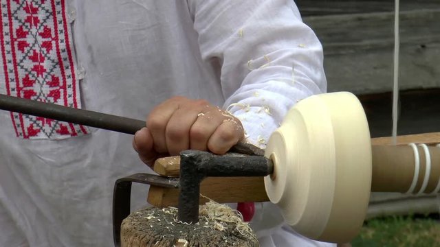 The video shows carpenter carves a cup on an old instrument clous up. Background