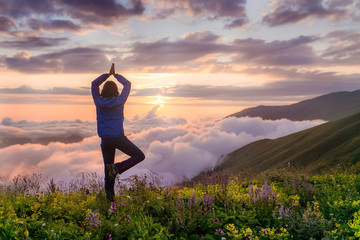 Young woman perform Yoga on the cliff in morning sunlight