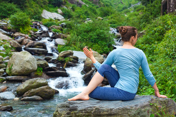 Woman doing Ardha matsyendrasana asana outdoors