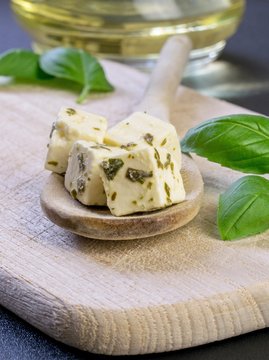 Traditional Greek feta cheese cubes on a wooden spoon