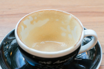 Empty coffee cup on white background. End of coffee break. Coffee grinds in mug.

