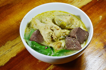 spicy chicken leg in green curry on bowl