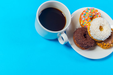 cup of coffee and donut isolated on blue background