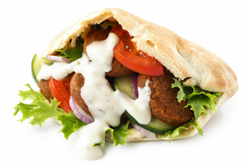 Pita bread filled with falafel, salad and white sauce isolated on white.